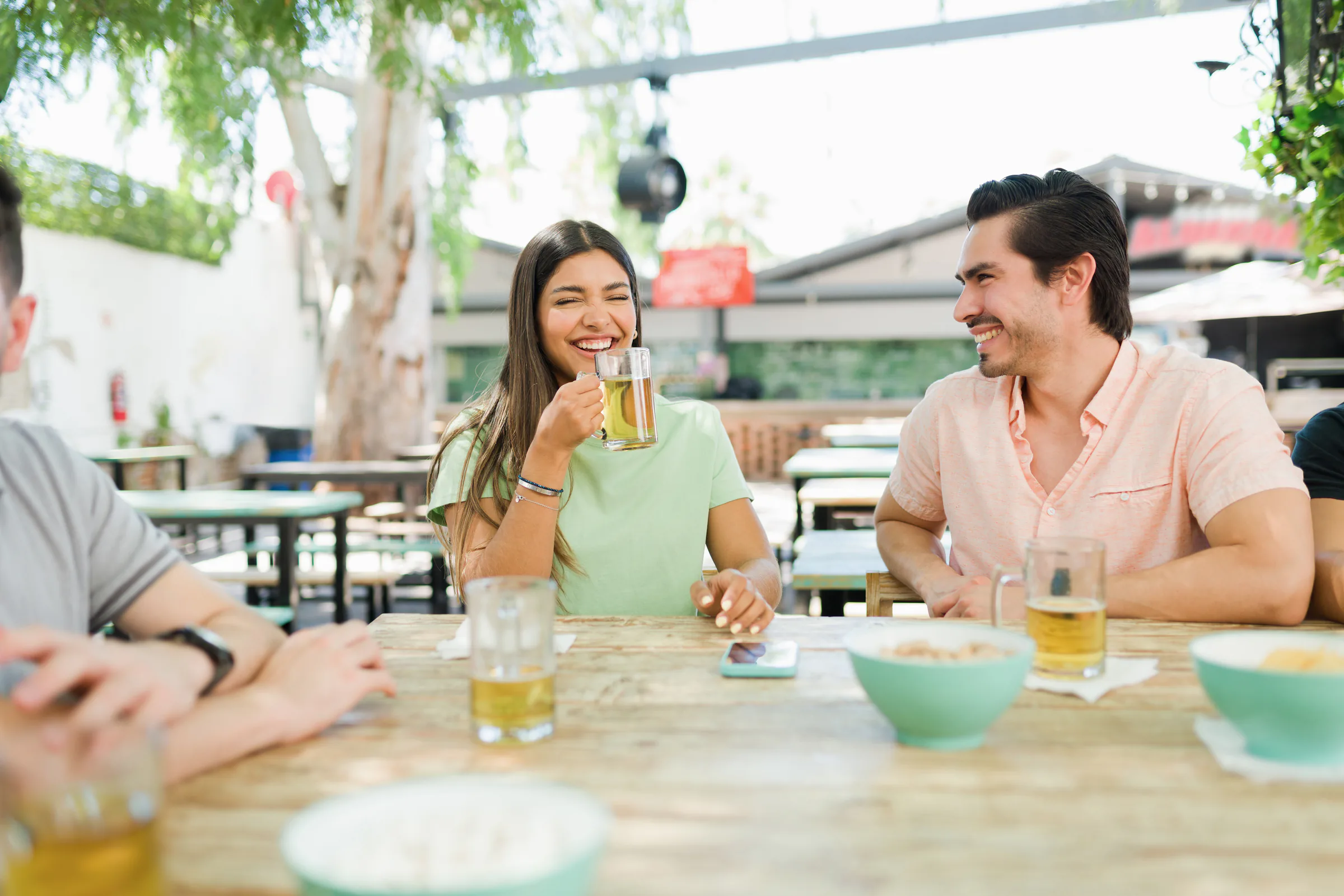 Amigos riendo y tomando cerveza en una terraza
