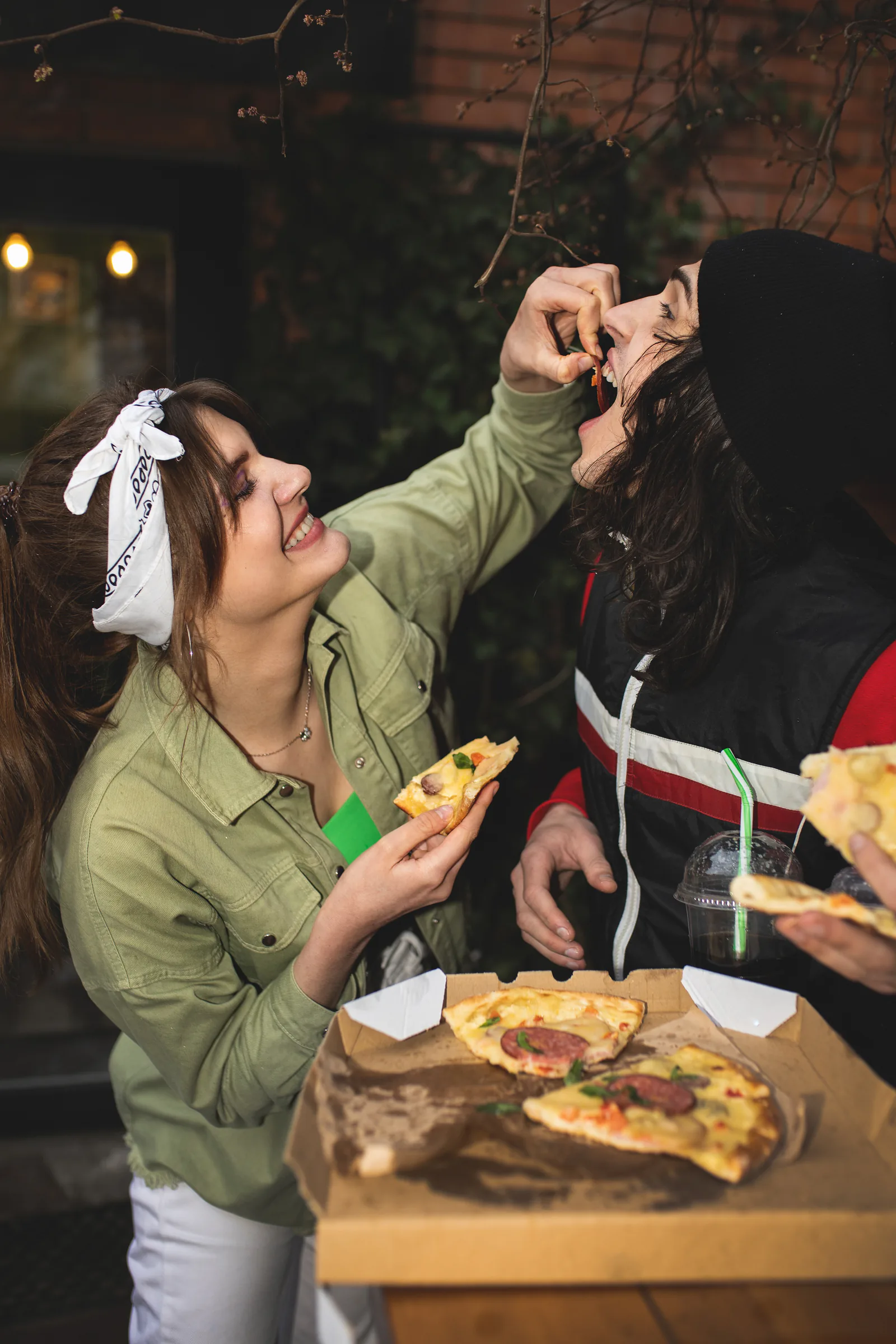 Amigos compartiendo pizza en la terraza de un restaurante
