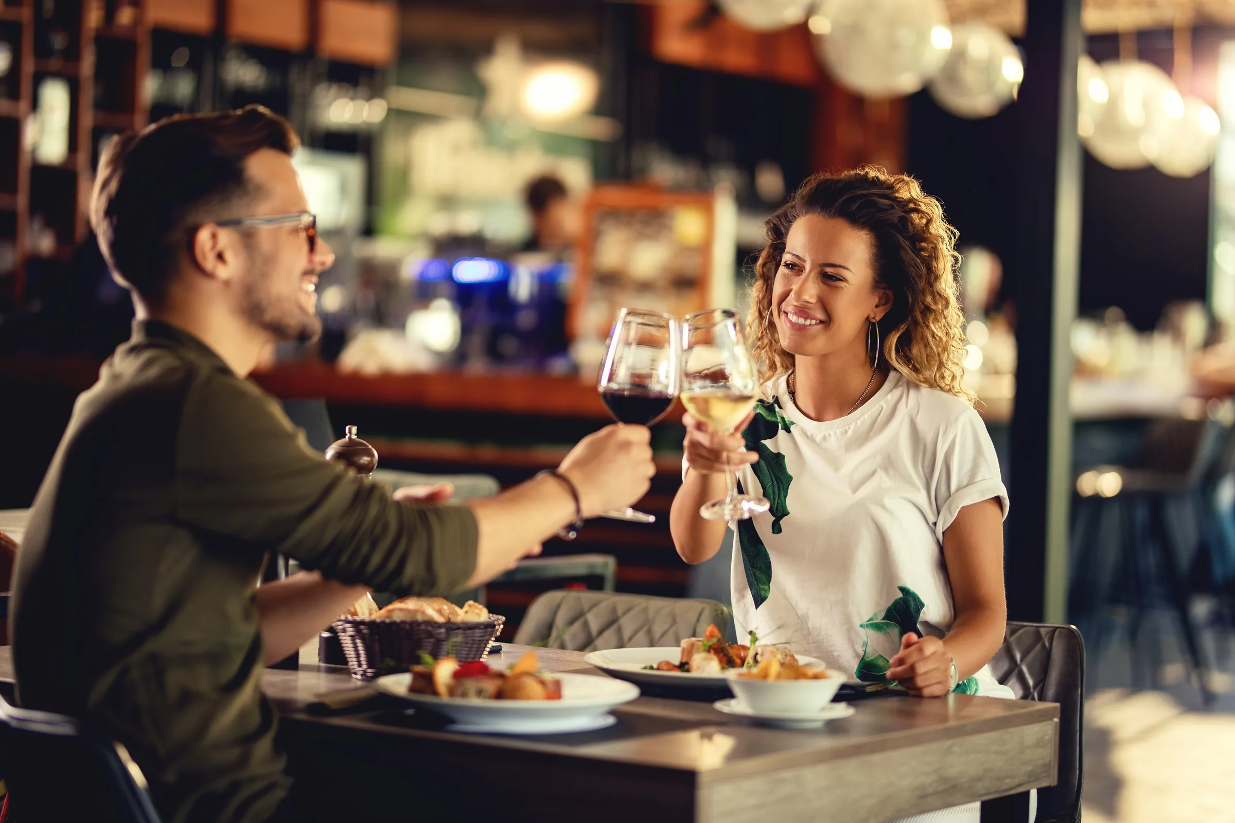 Pareja brindando con vino durante una comida en un restaurante